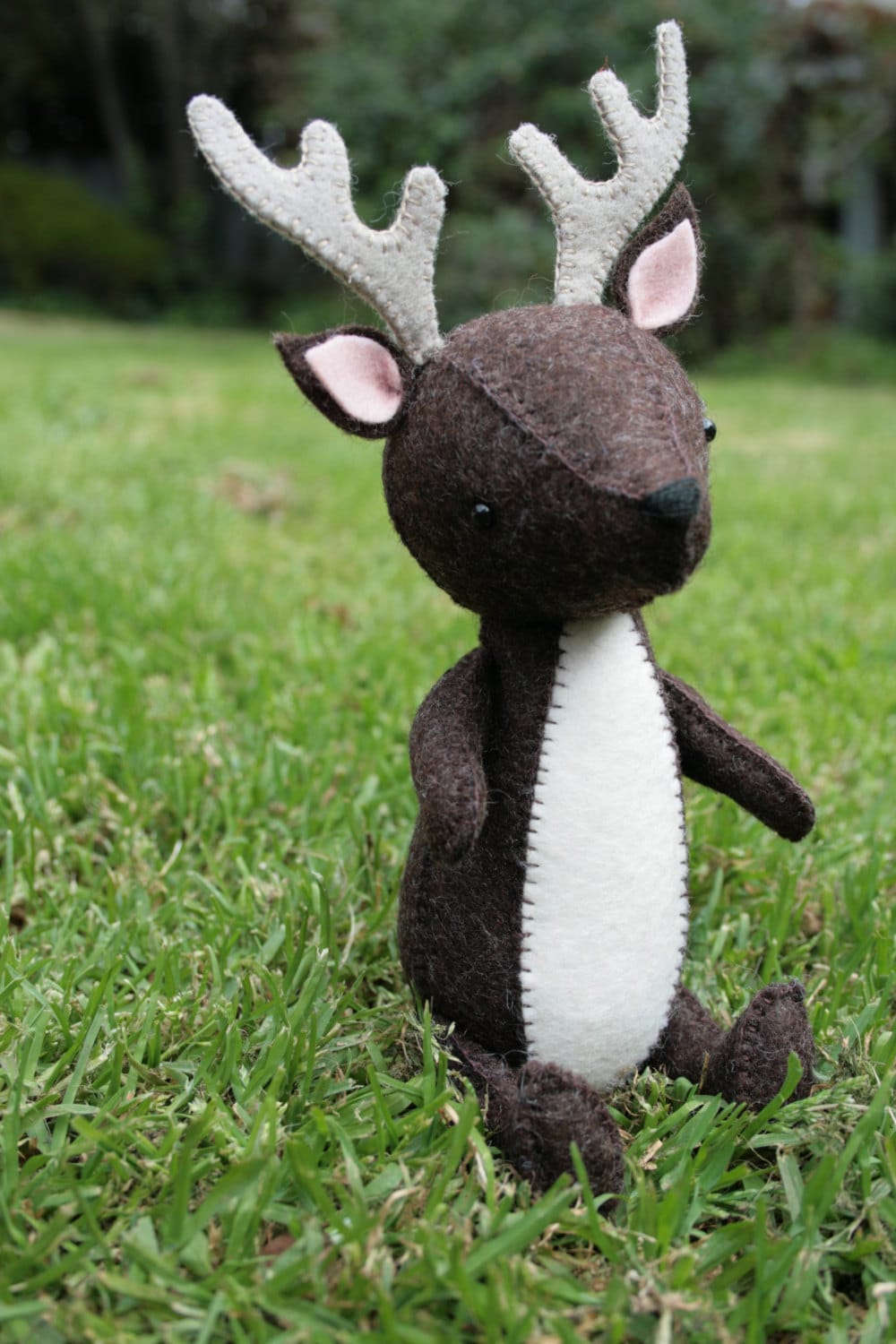 handsewn felt deer sitting on grass