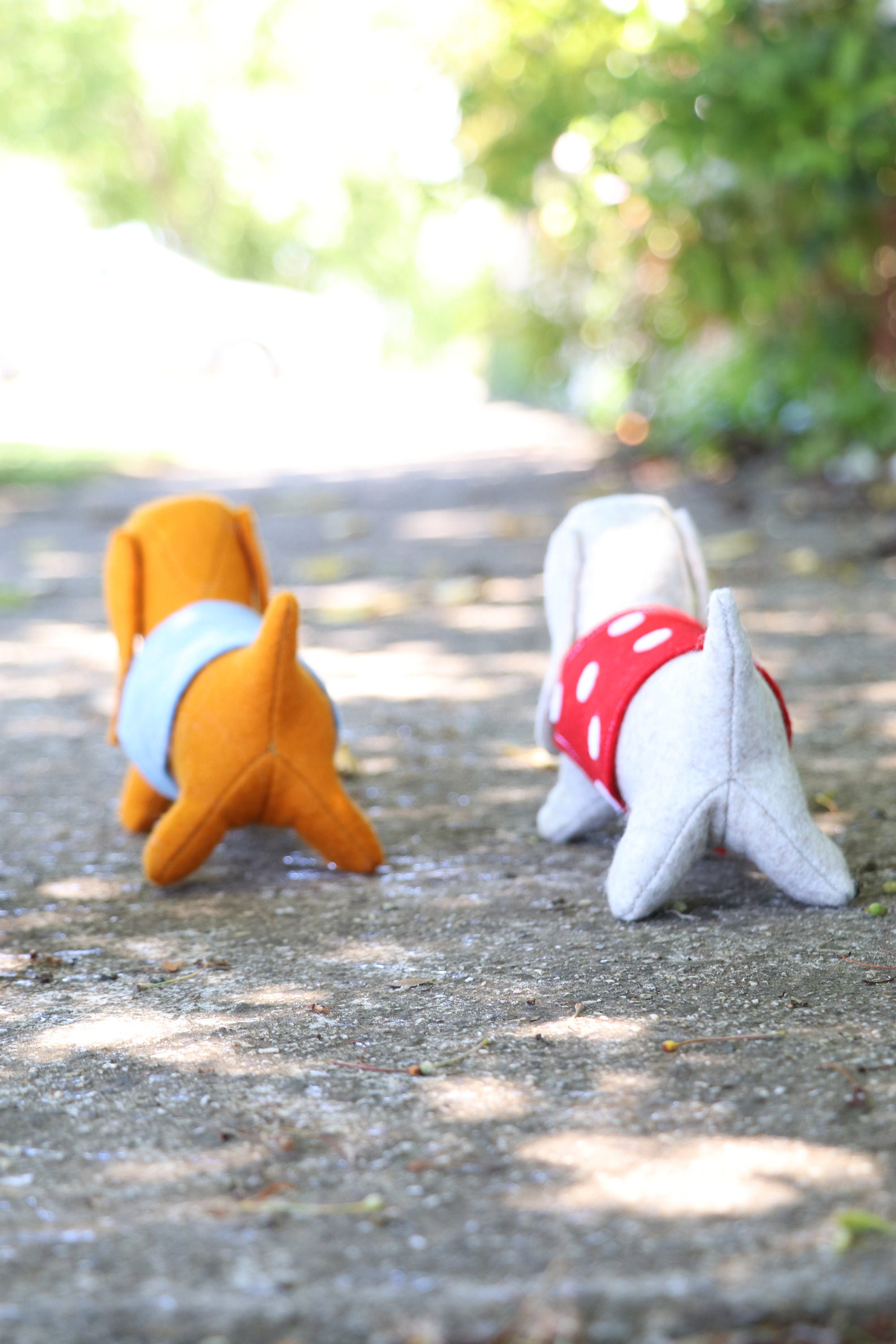 two felt dogs walking away