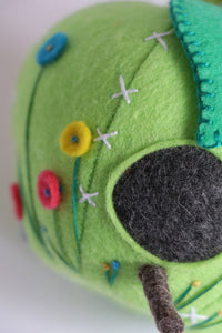 close up of green felt apple shaped pincushion