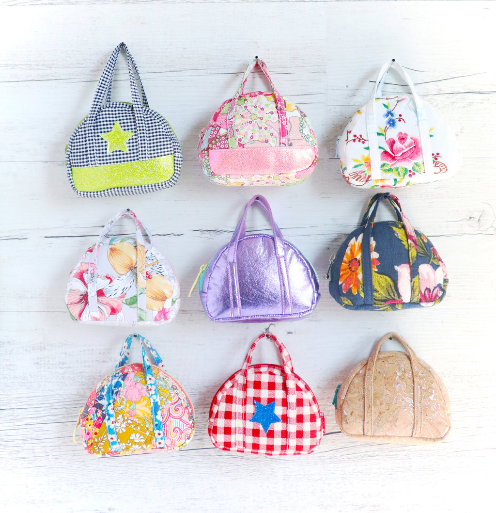 nine tiny bowling bags hanging on a wall