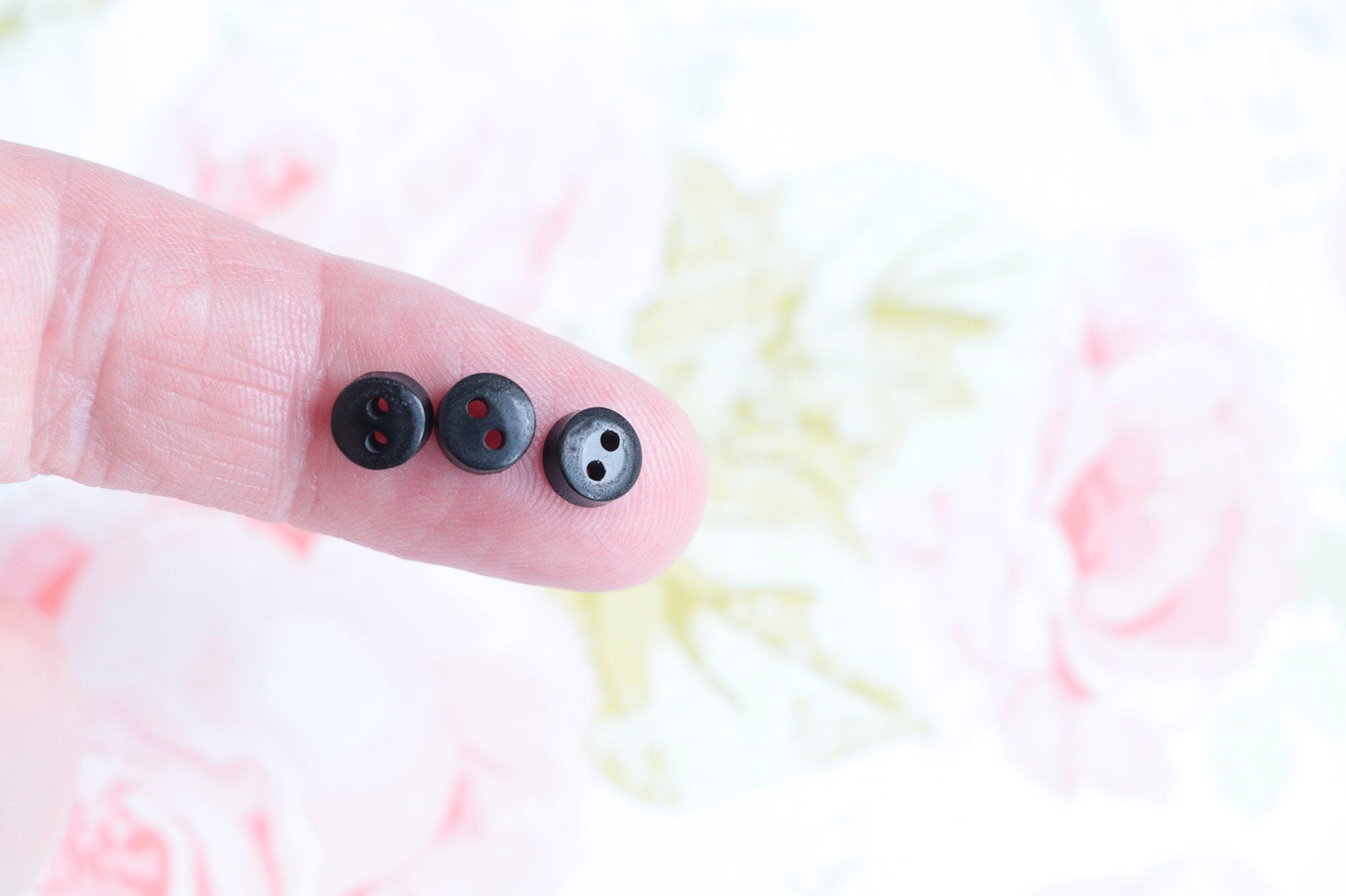 three 5mm black buttons